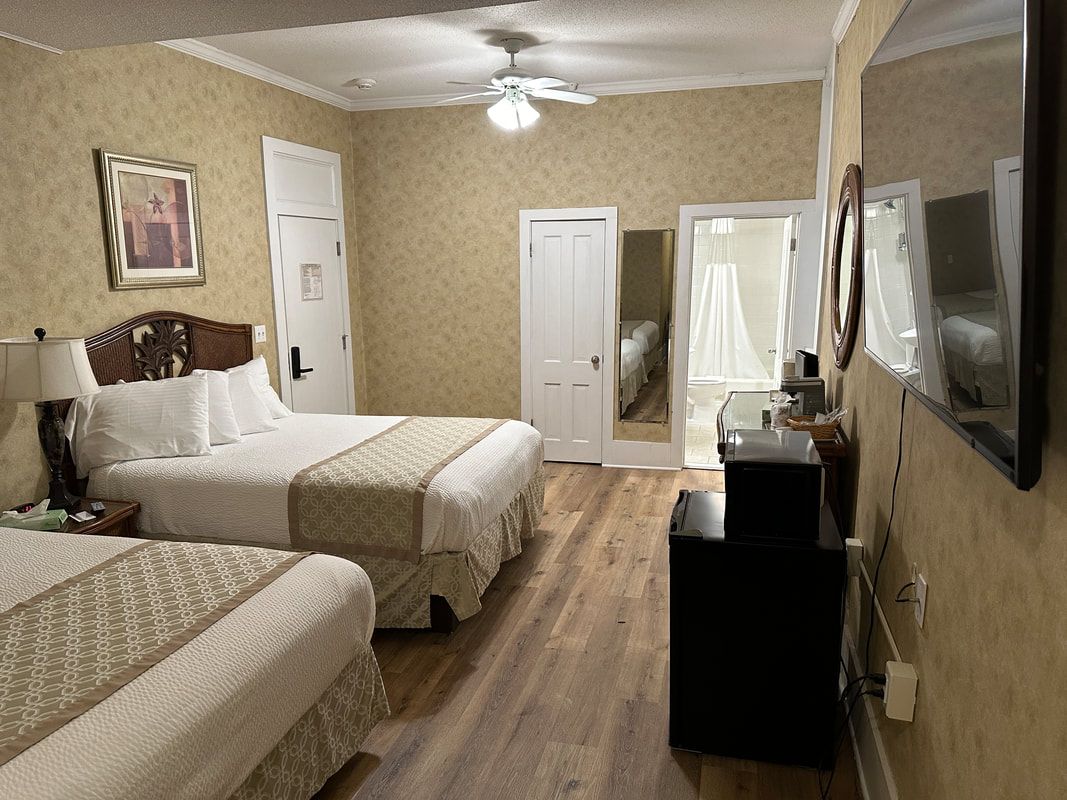 A hotel room with two beds and a flat screen tv.