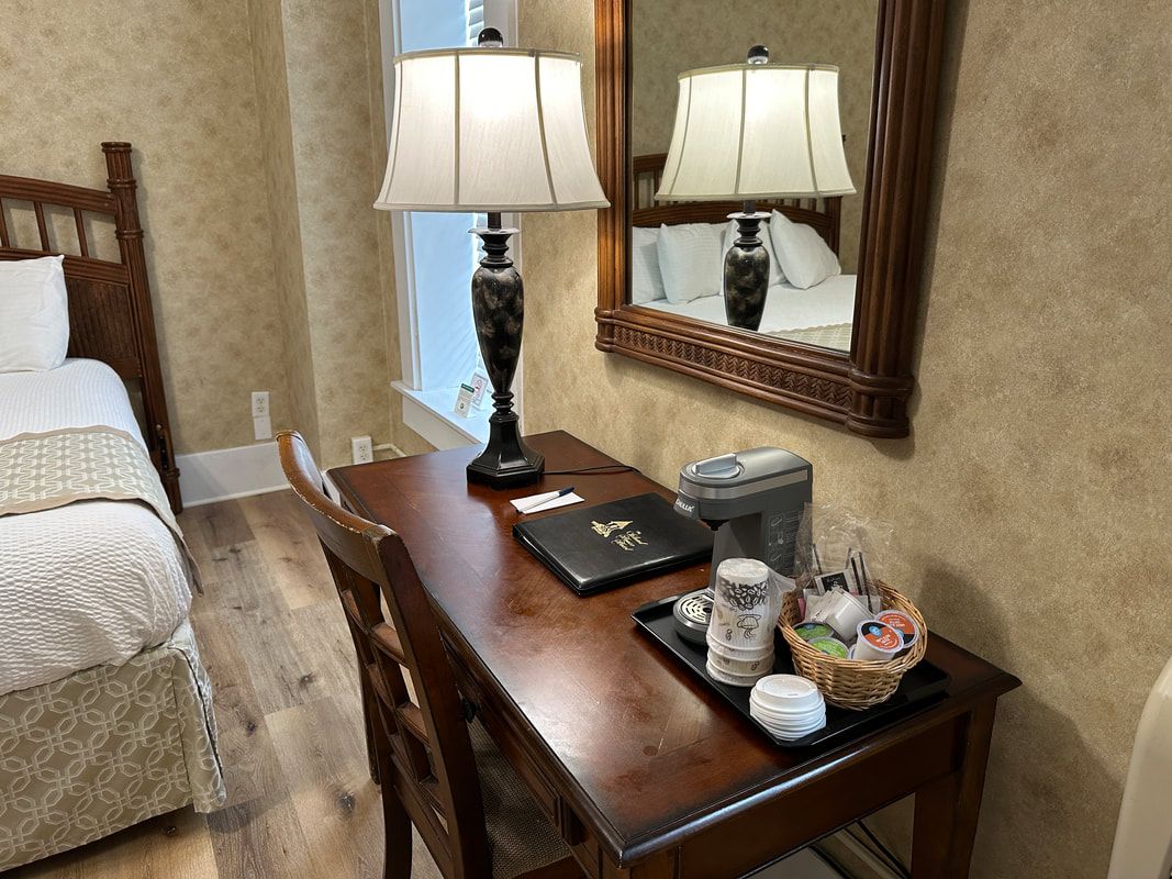 There is a desk with a laptop on it in a hotel room.