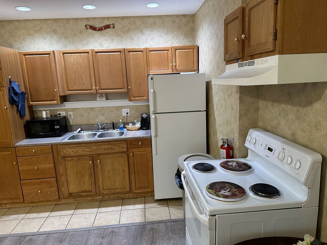 A kitchen with a stove , refrigerator , sink and microwave.