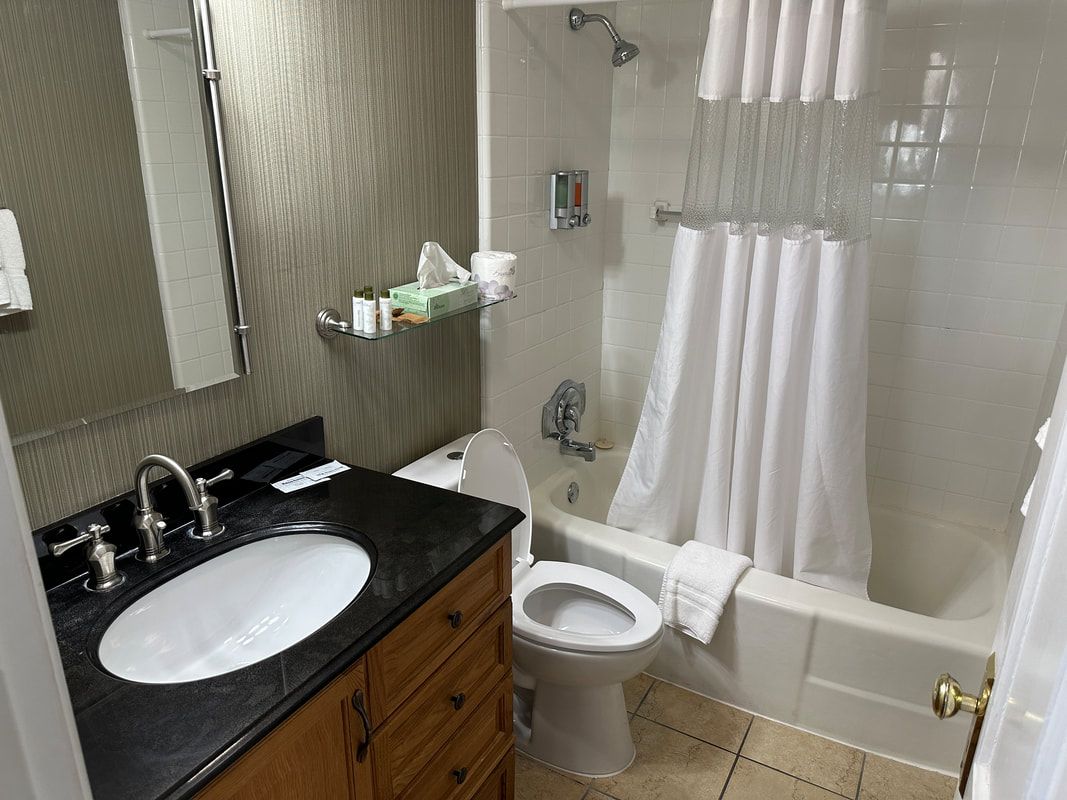 A bathroom with a sink , toilet , tub and shower.