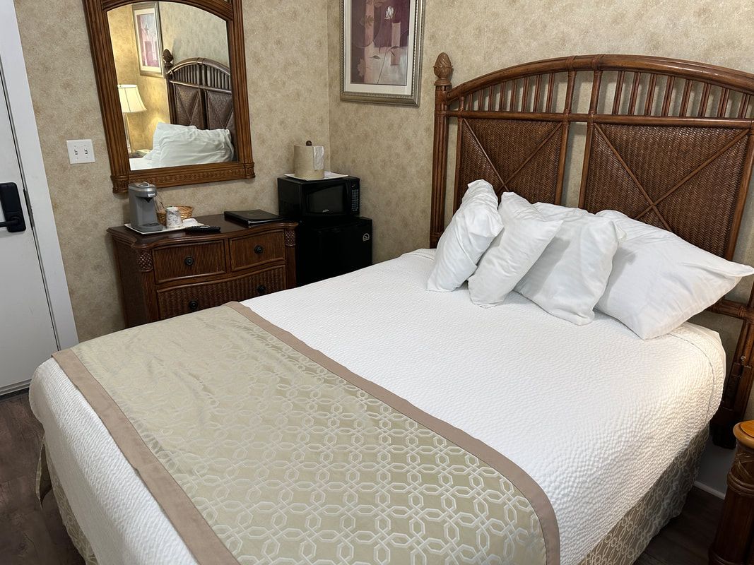 A hotel room with a king size bed and a mirror.