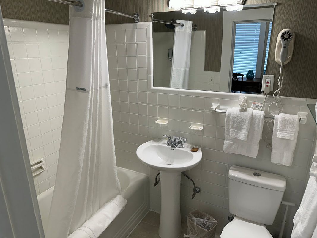 A bathroom with a sink , toilet , bathtub and mirror.
