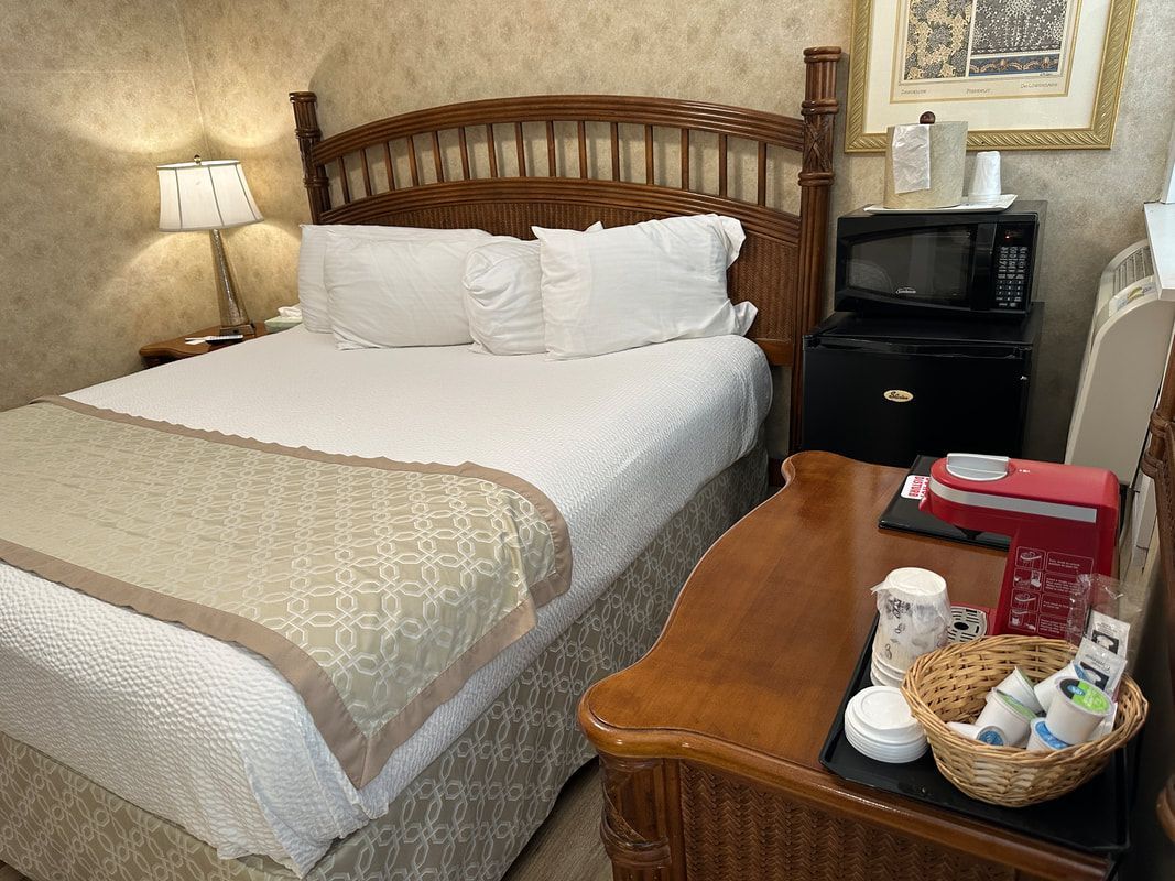 A hotel room with a bed , table , and microwave