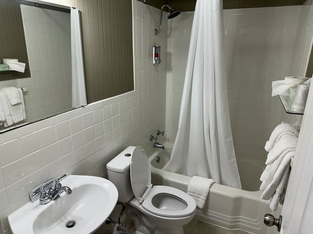A bathroom with a toilet , sink and bathtub.