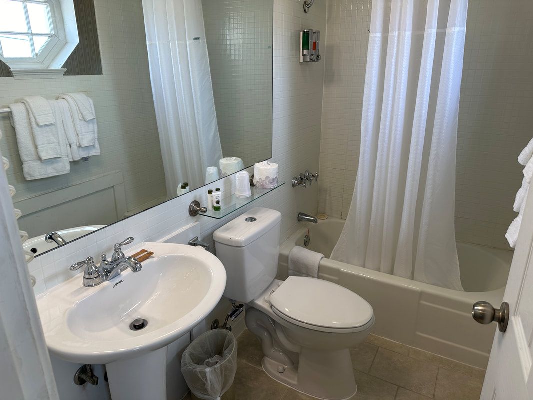 A bathroom with a toilet , sink , and bathtub.