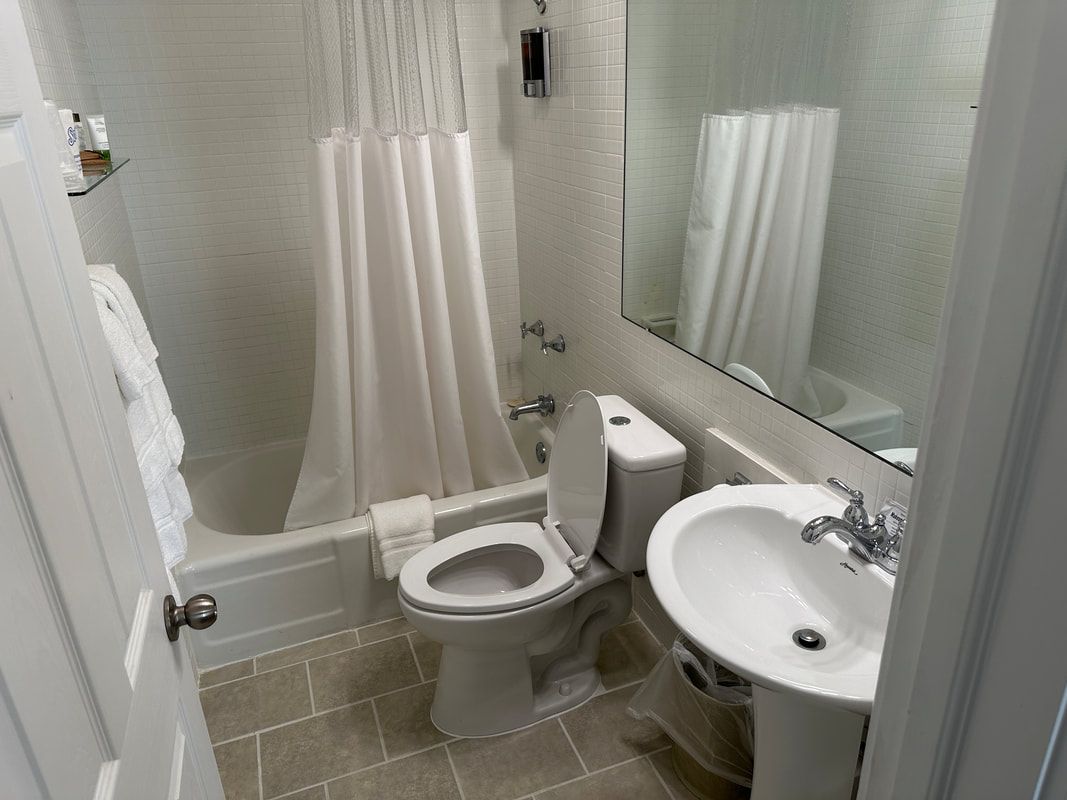 A bathroom with a toilet , sink and bathtub.