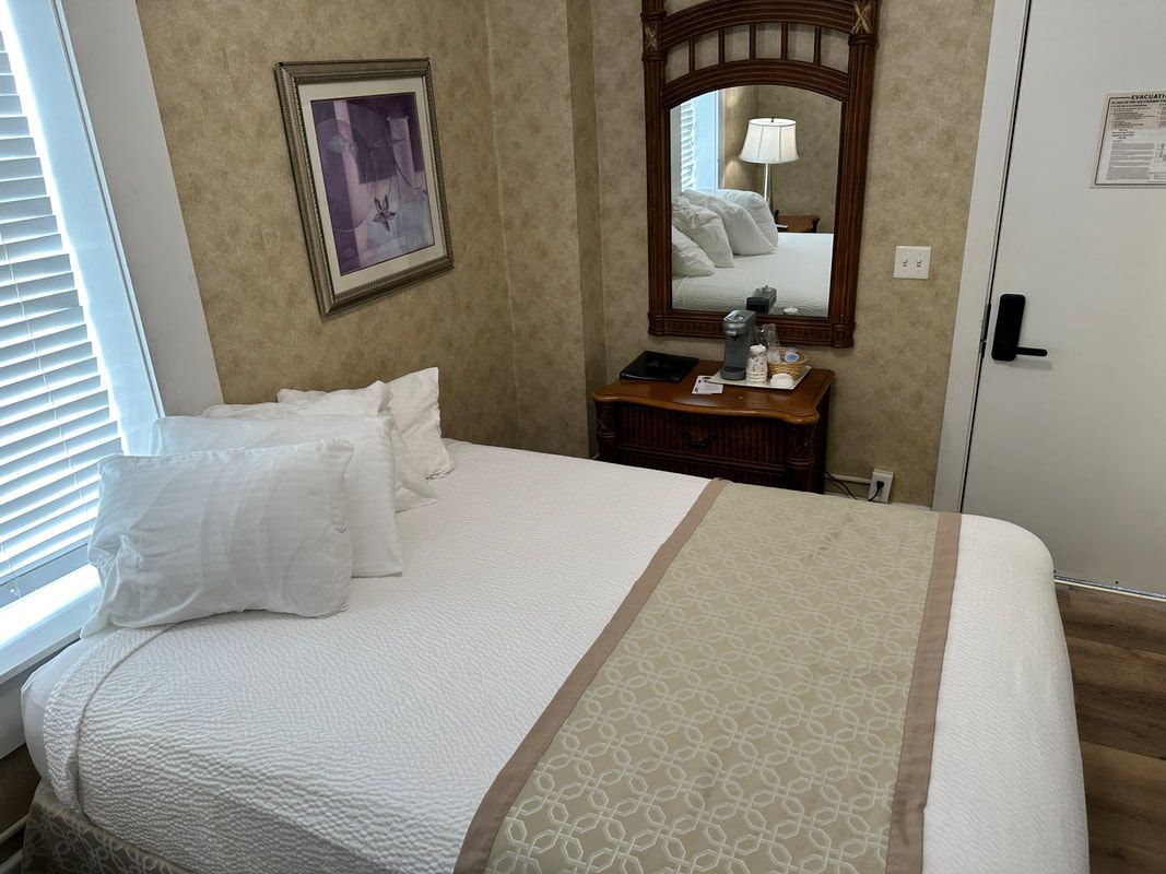 A hotel room with a bed and a mirror
