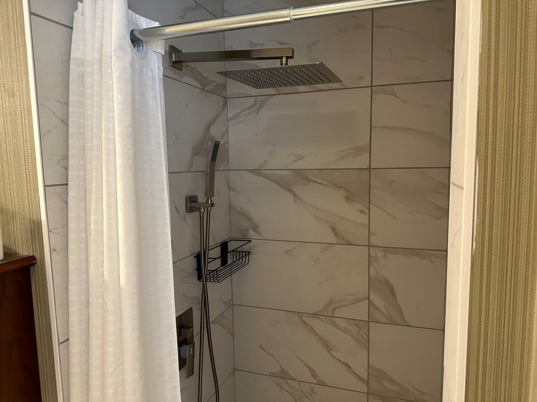 A bathroom with a shower curtain and a shower head.