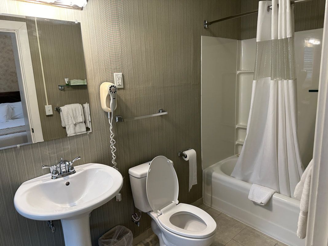 A bathroom with a toilet , sink , and bathtub.