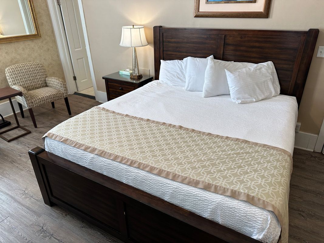 A hotel room with a king size bed and a chair.