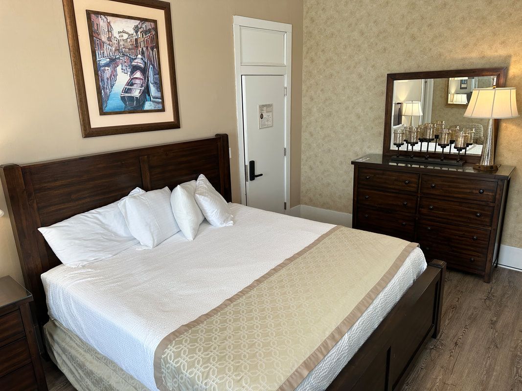 A bedroom with a bed , dresser and mirror