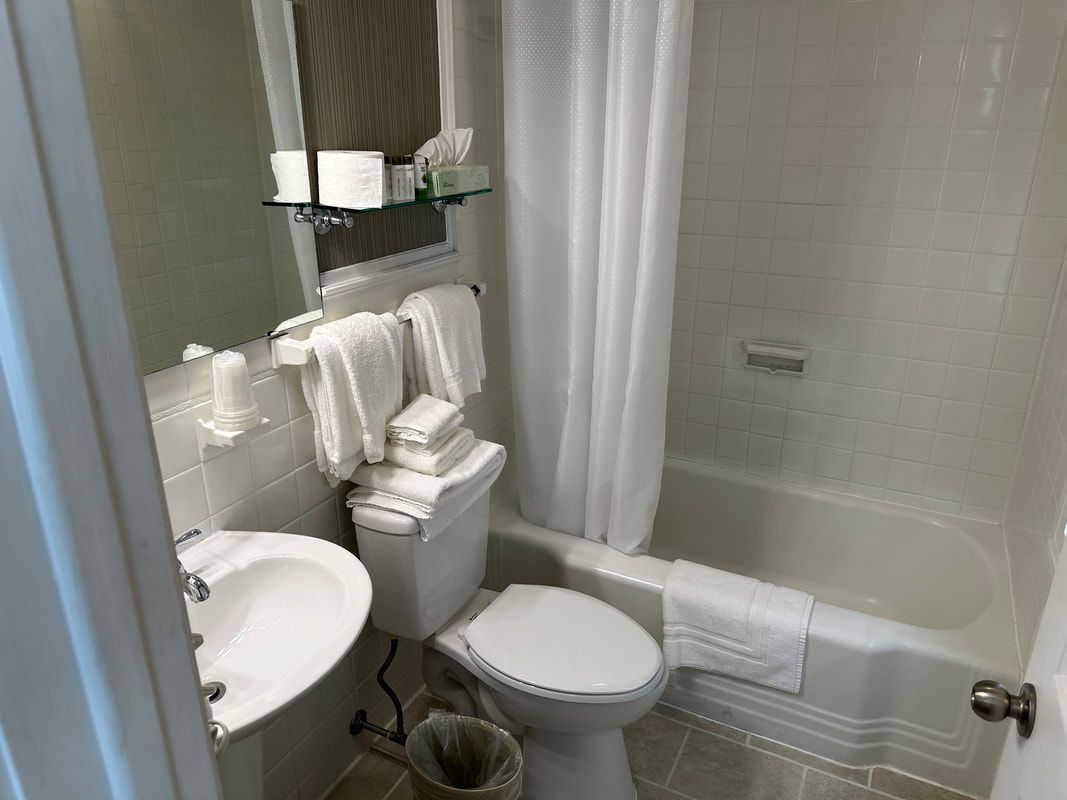 A bathroom with a toilet , sink , and bathtub.
