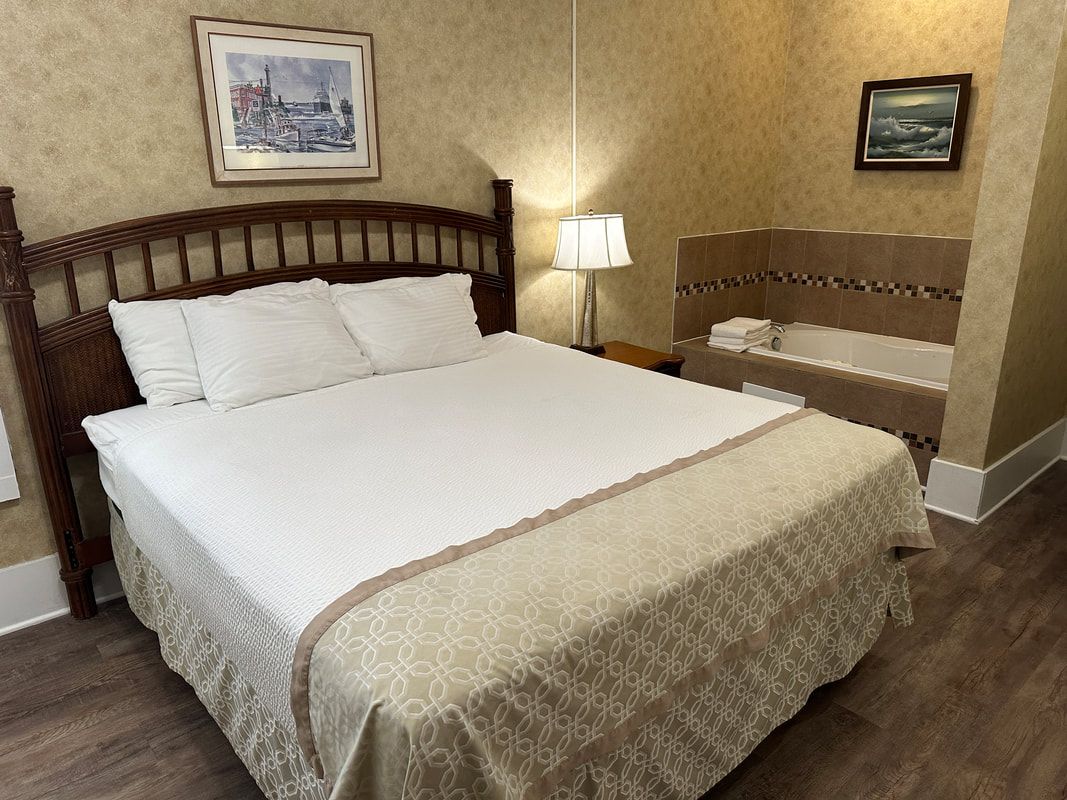 A hotel room with a king size bed and a jacuzzi tub.