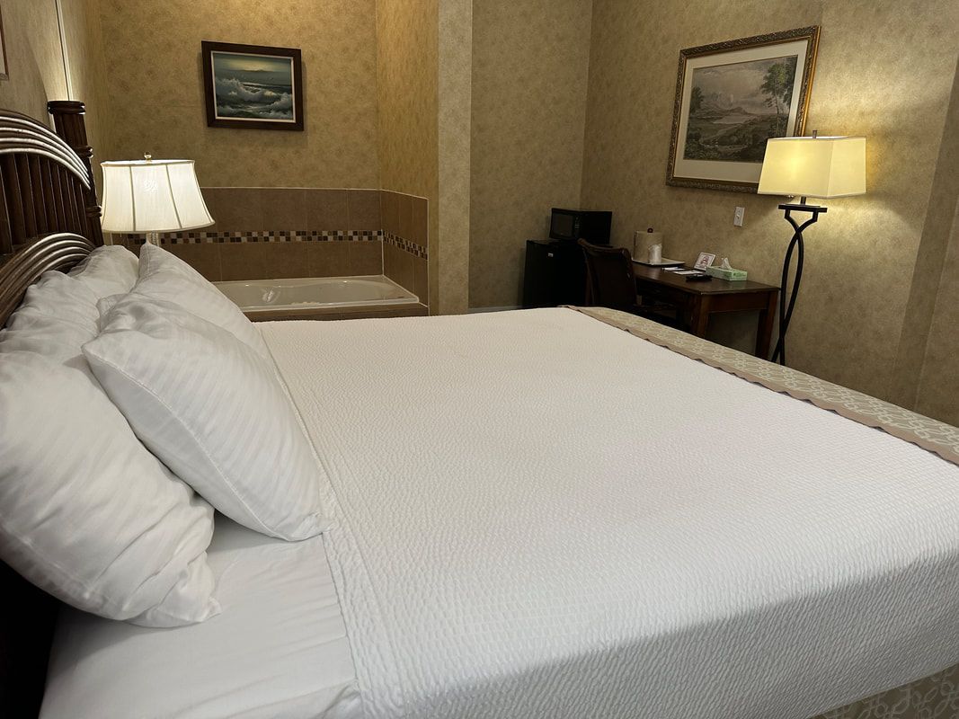 A hotel room with a king size bed and a jacuzzi tub