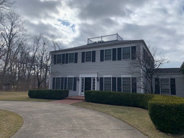 A large white house with a driveway leading to it