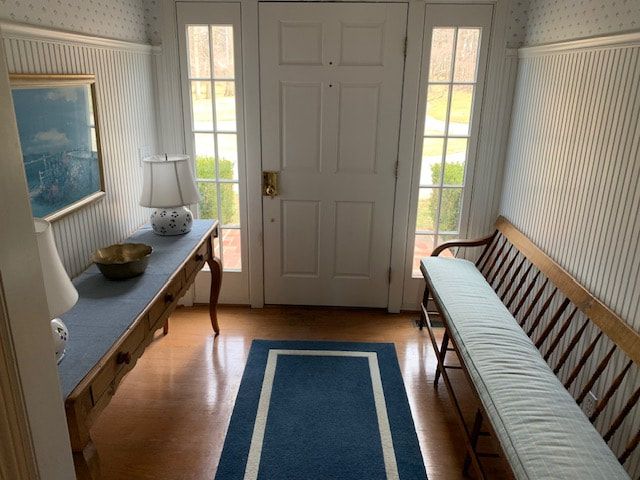 A hallway with a blue rug and a bench