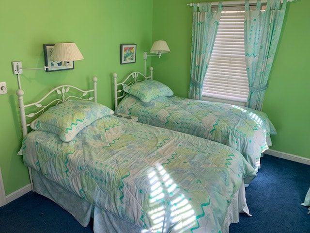 A bedroom with two twin beds and green walls