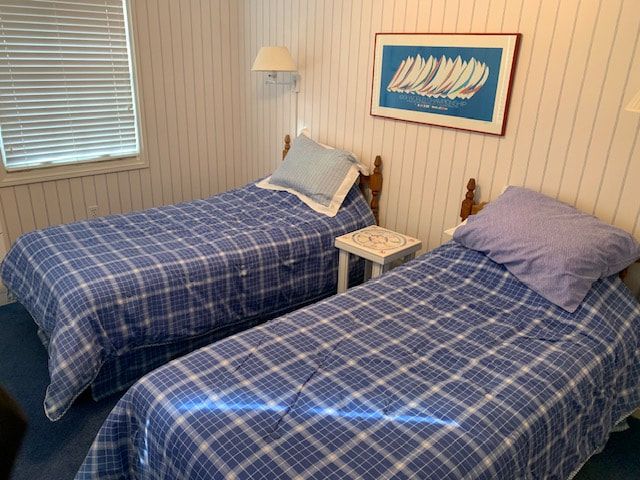 A bedroom with two beds and a picture on the wall