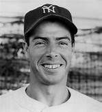 A black and white photo of a man wearing a baseball cap and smiling.