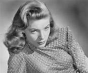 A black and white photo of a woman in a sweater.