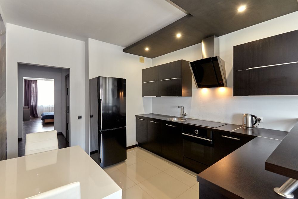 A Kitchen With Black Cabinets and a Black Refrigerator — Suncoast Kitchens In Kunda Park, QLD