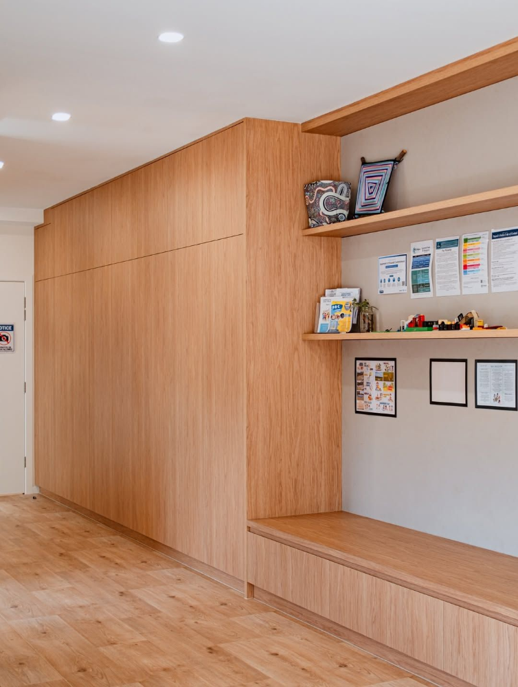 Modern hallway with light wood paneling, built-in shelves, and a wall-mounted display area.— Suncoast Kitchens In Kunda Park, QLD