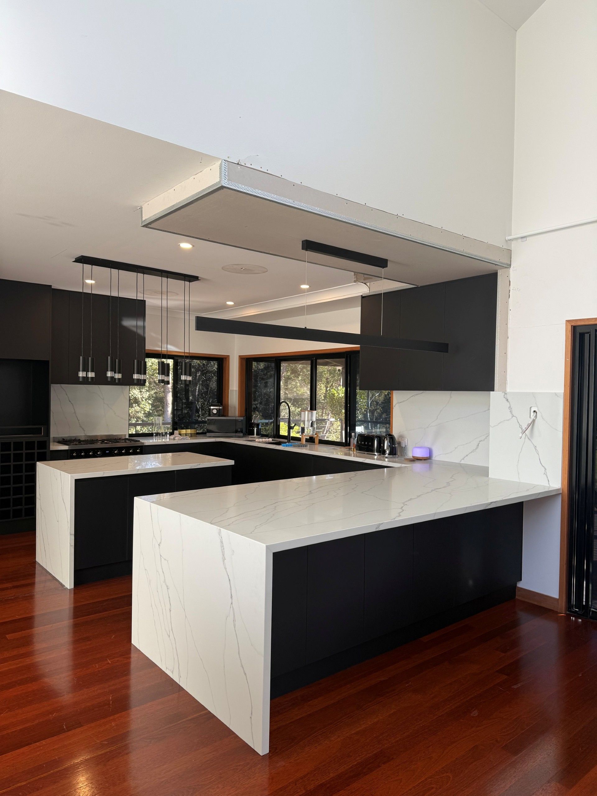 A Kitchen With White Cabinets and a Stove Top Oven — Suncoast Kitchens In Kunda Park, QLD