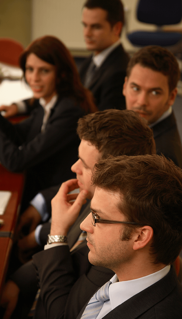 A group of people in suits and ties are sitting at a table