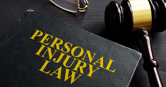 A book titled personal injury law is on a table next to a judge 's gavel.