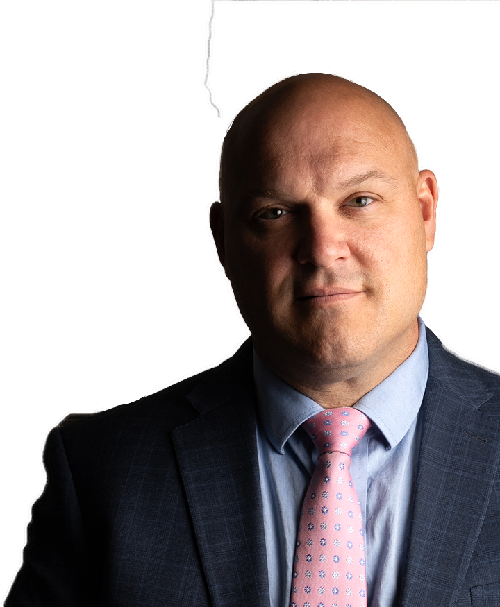 A bald man wearing a suit and pink tie