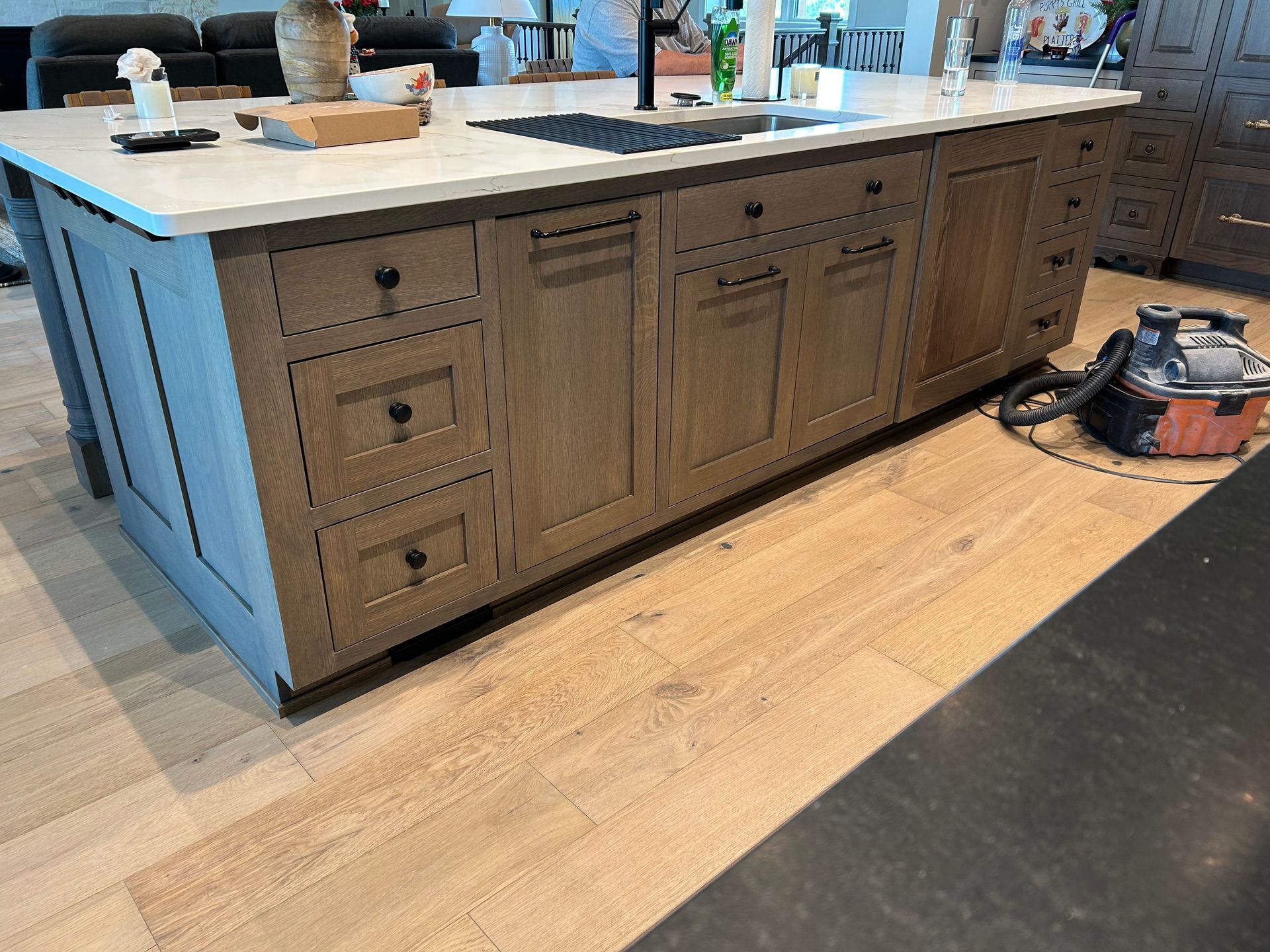 Kitchen island with drawers and cabinet doors, topped with a light countertop in a modern room.