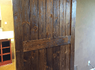 Rustic wooden sliding door with dark planks in an interior room