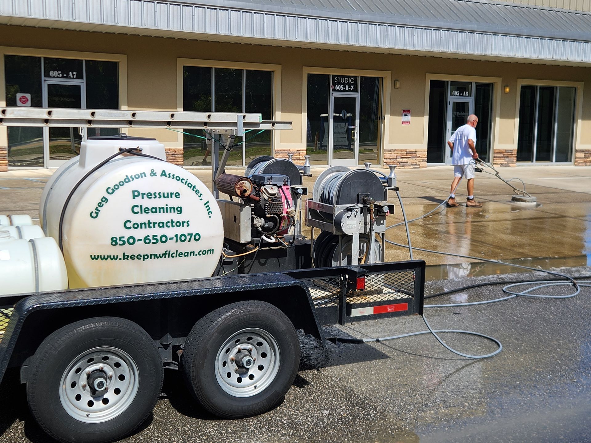 Professional pressure washing technician cleaning a concrete driveway