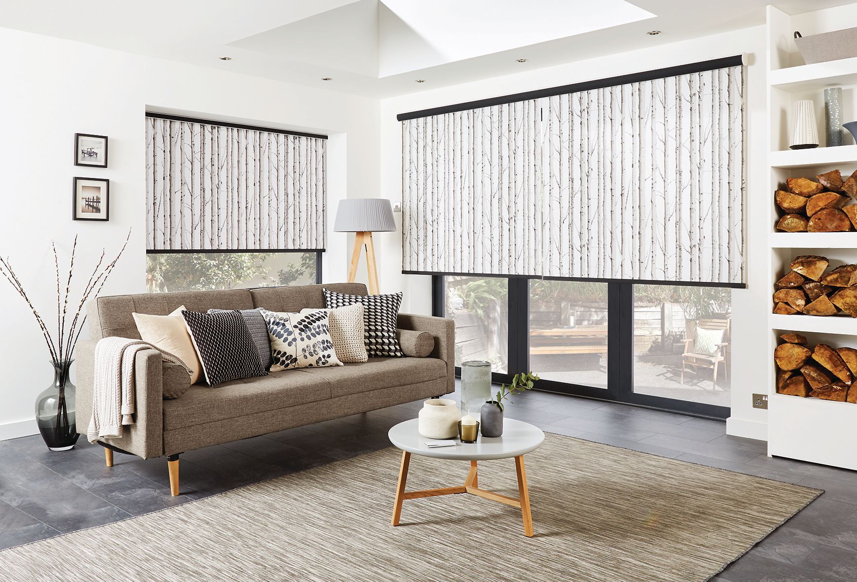 Living room with sofa, rug, patterned blinds, and a wood storage shelf.  Abundance Blinds In Charmhaven, NSW