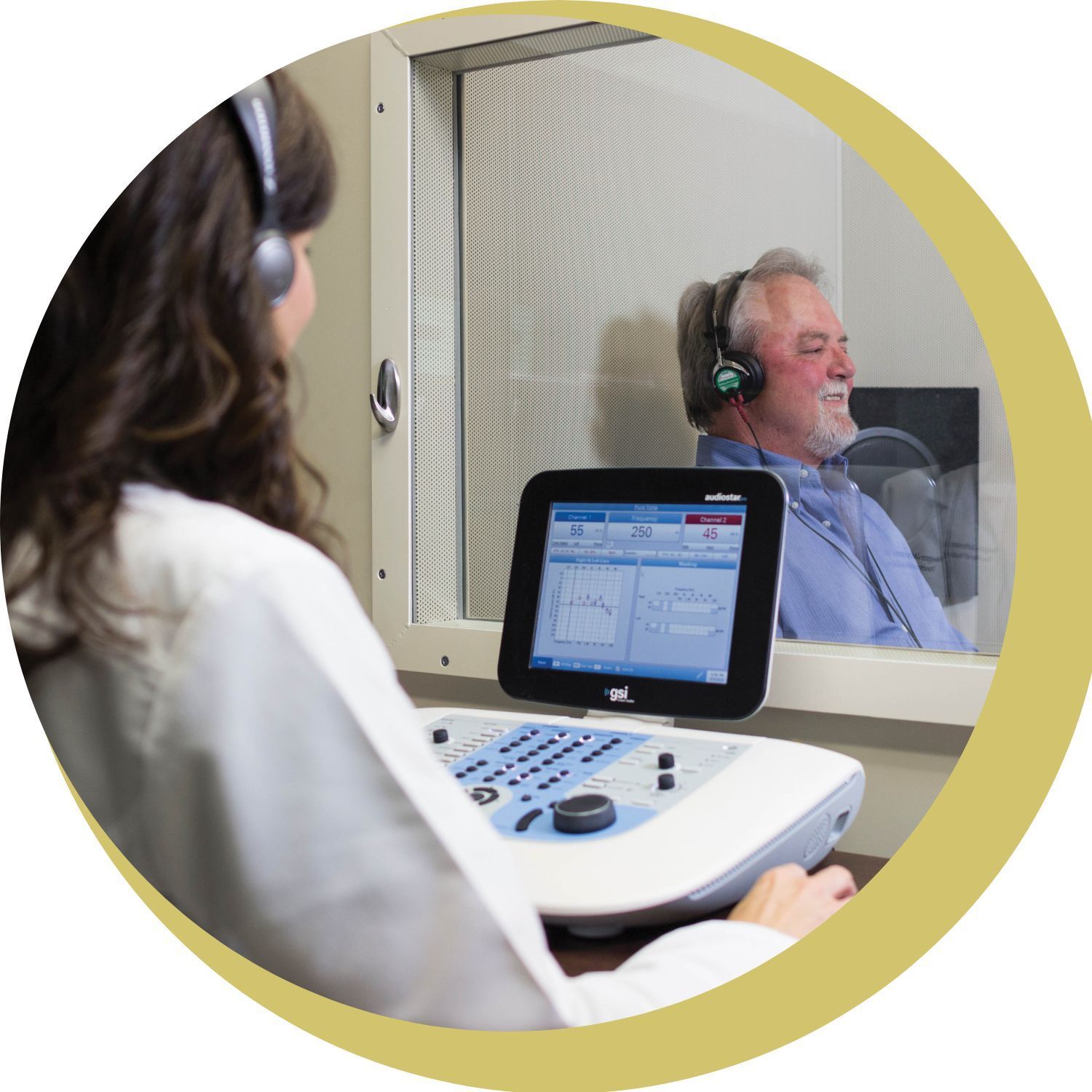 A person is holding a pair of hearing aids in their hand