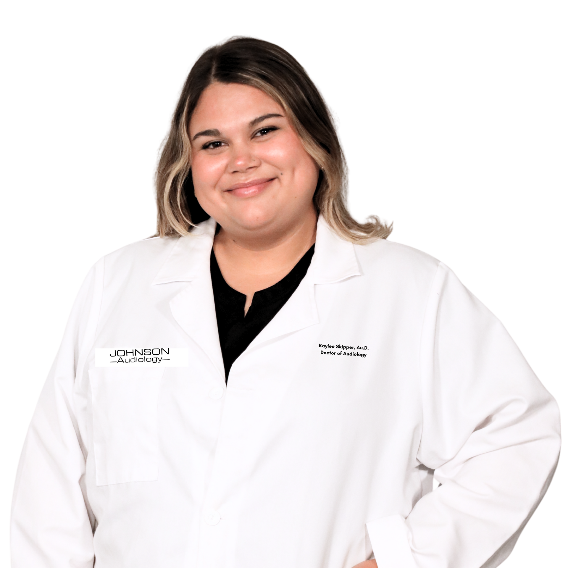 Woman in a white lab coat, smiling, with light brown hair, and a black top.
