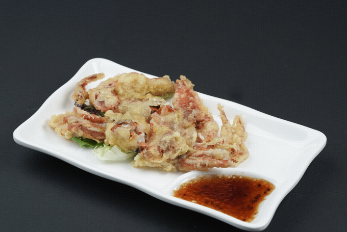 Fried crab on a white plate with dipping sauce