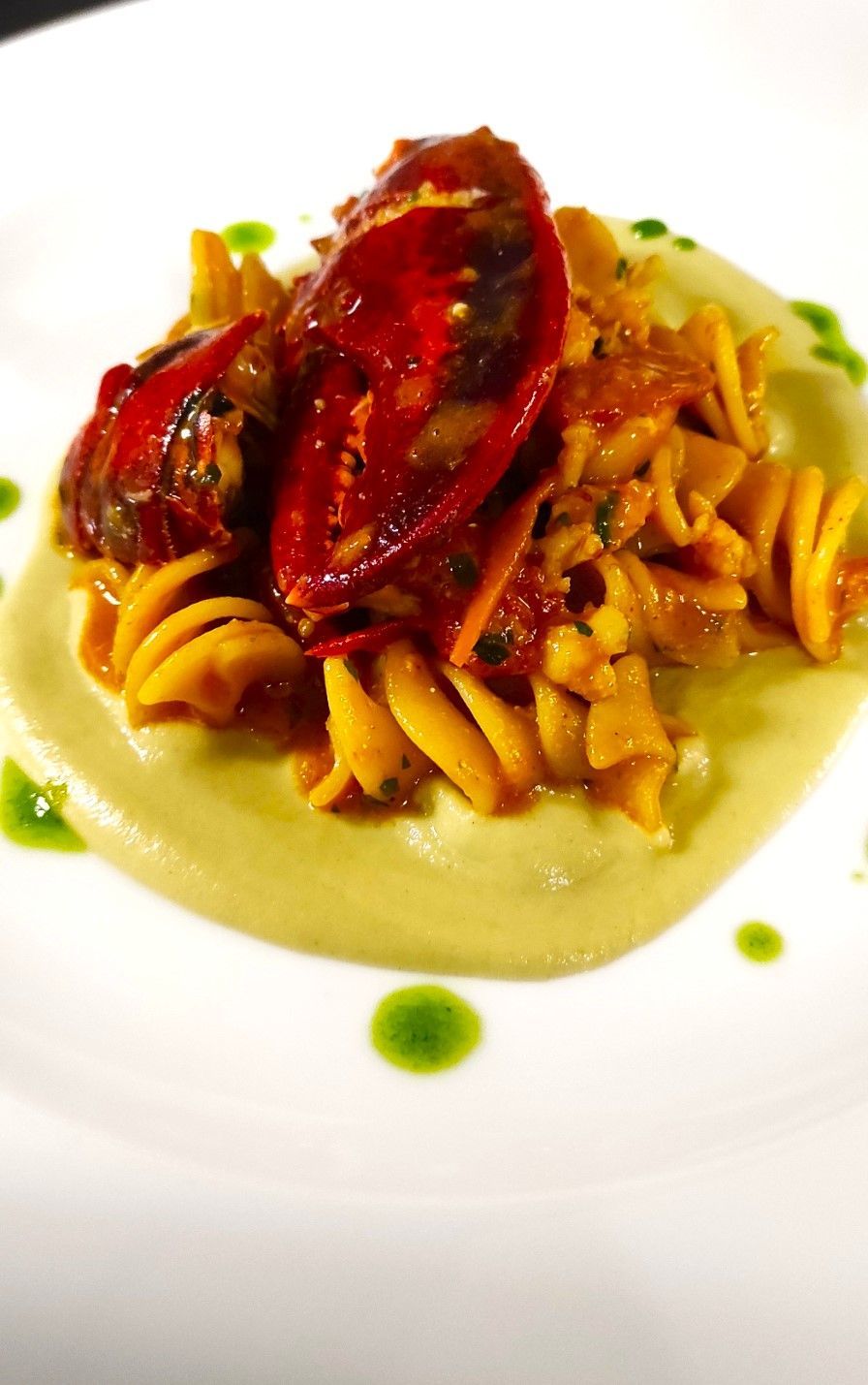 Un piatto bianco condito con salsa di pasta e pomodori