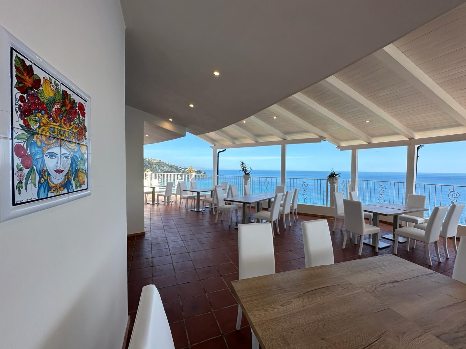 Una sala da pranzo con tavoli e sedie e un dipinto sul muro