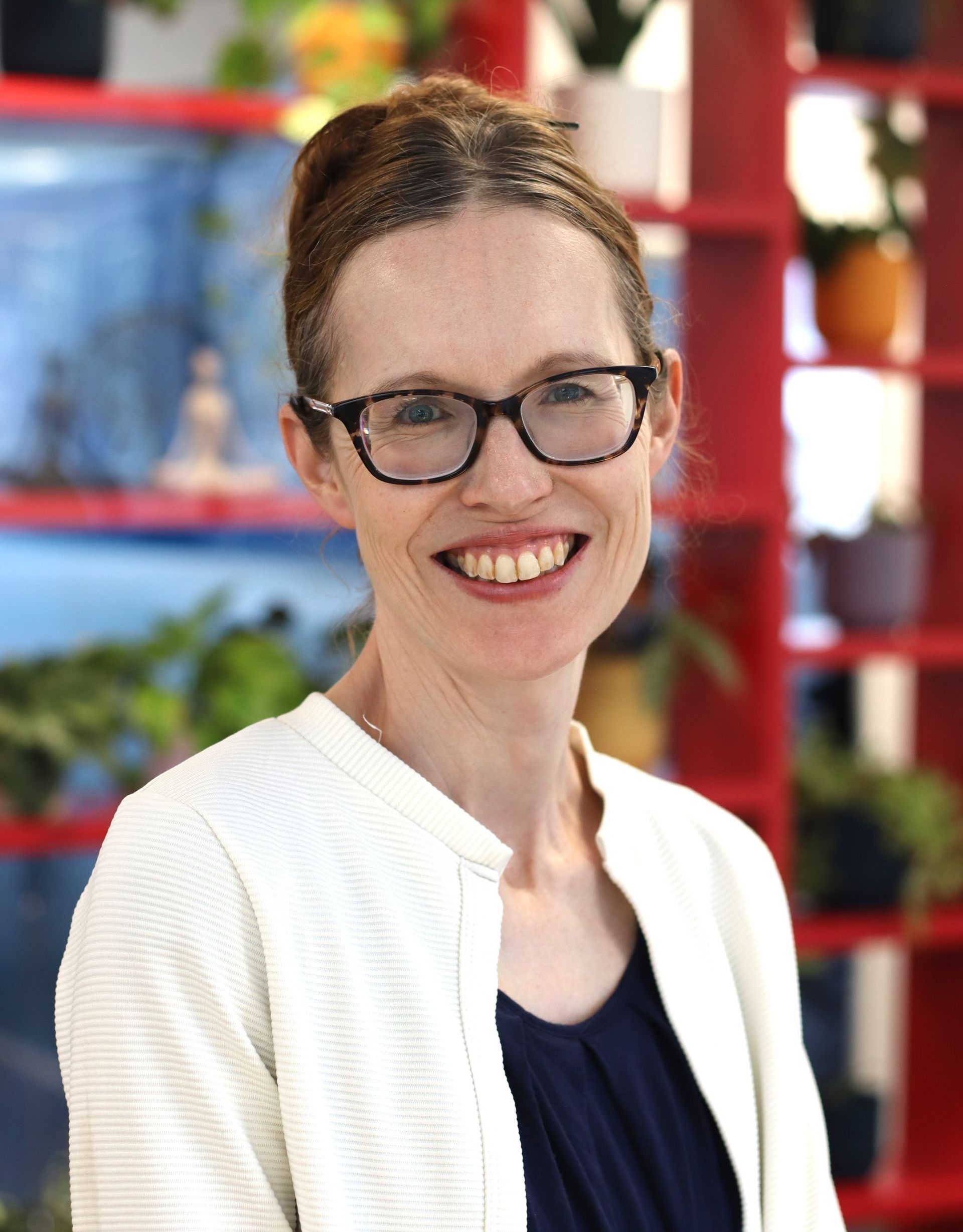 Smiling woman in a blue blouse against a light gray background