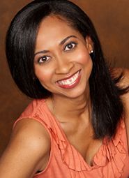 Smiling woman with long dark hair in a coral top against a brown background