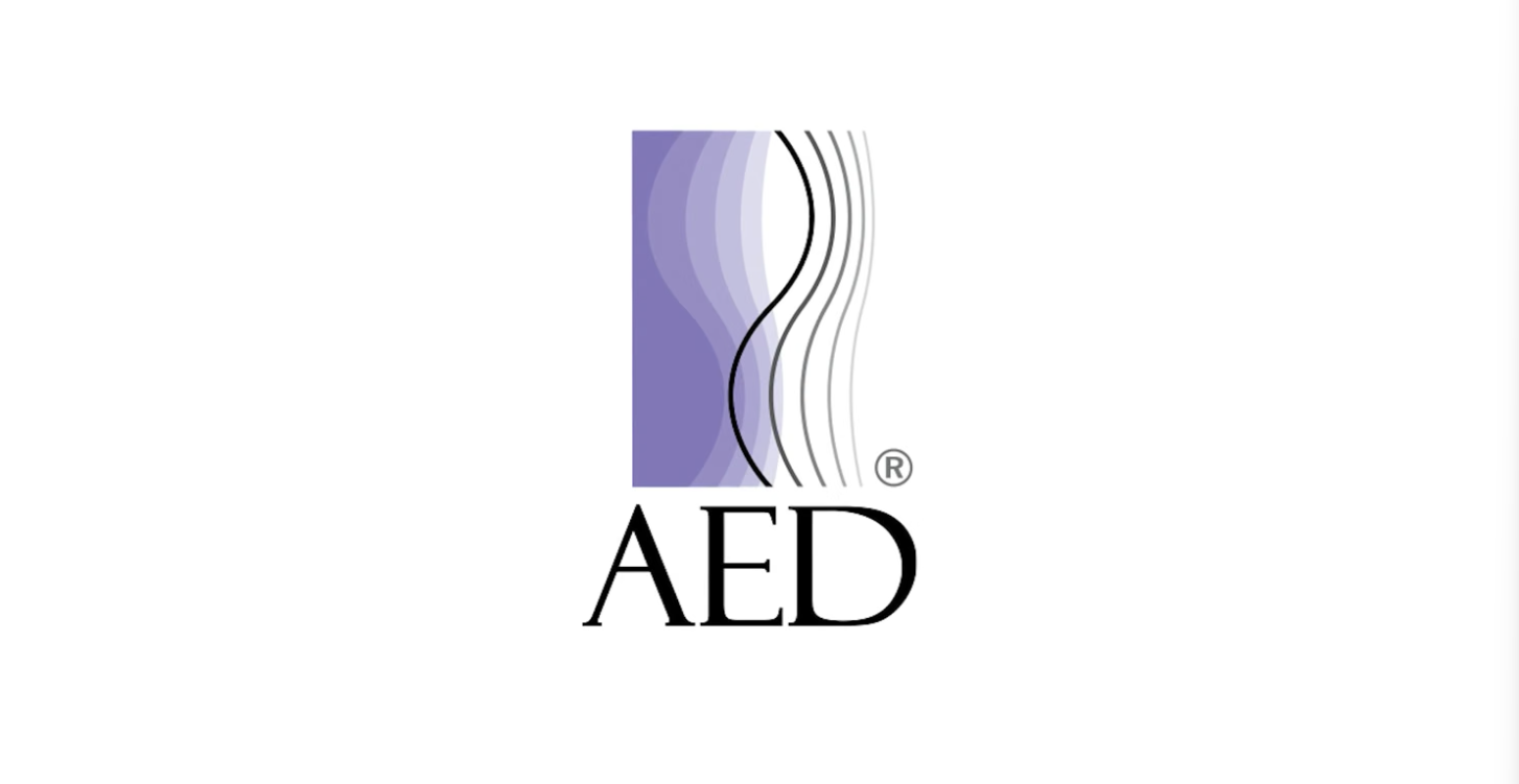 AED logo with purple wavy lines above black letters on a white background