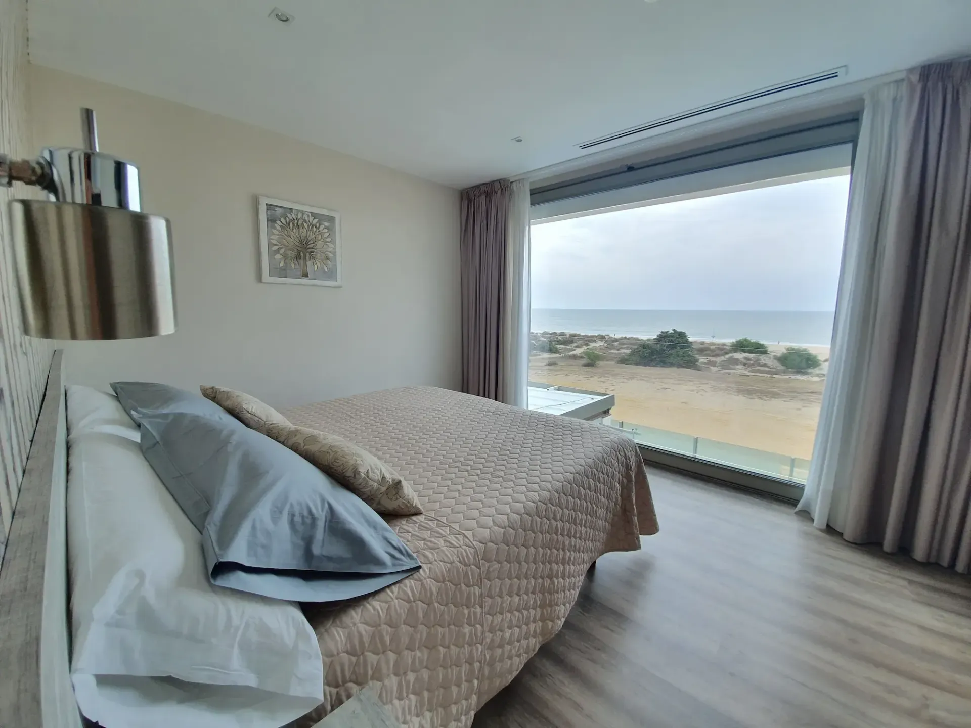Dormitorio Doble DeLUxe con un gran ventanal con vistas Panorámicas a la playa y al océano, y baño en suite. Planta Superior