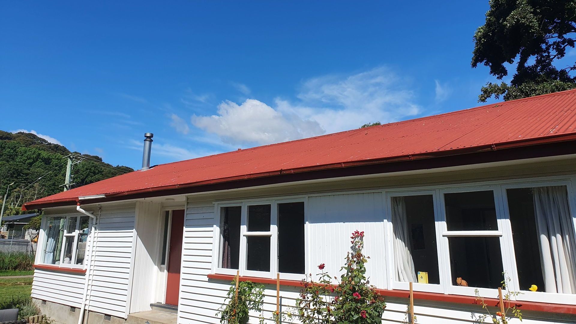 A white house with a red roof and a blue sky in the background.