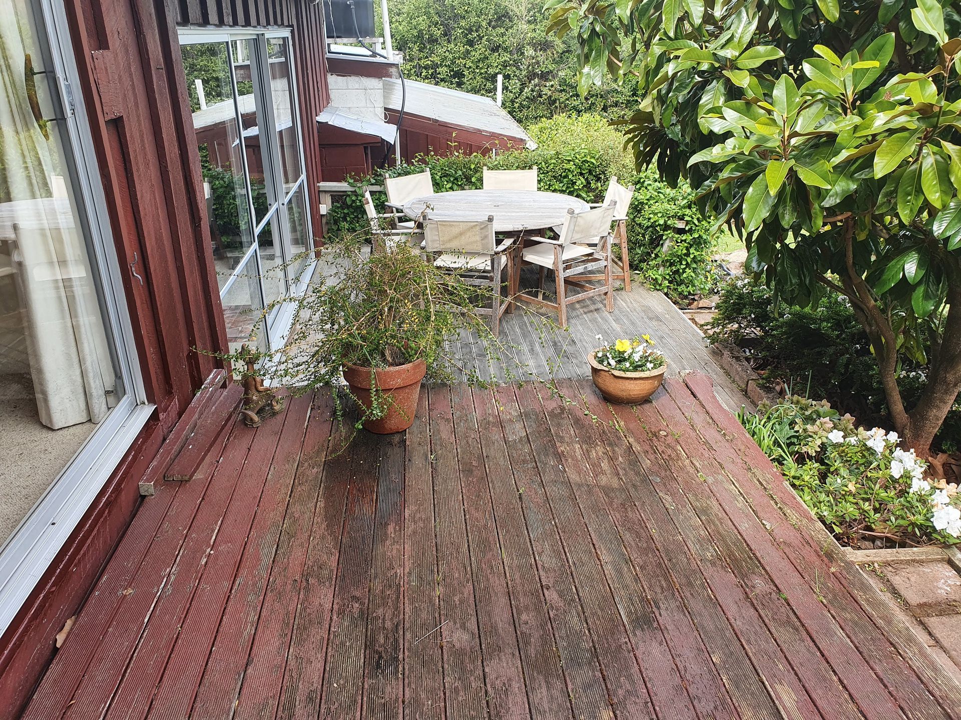There is a wooden deck with a table and chairs on it.