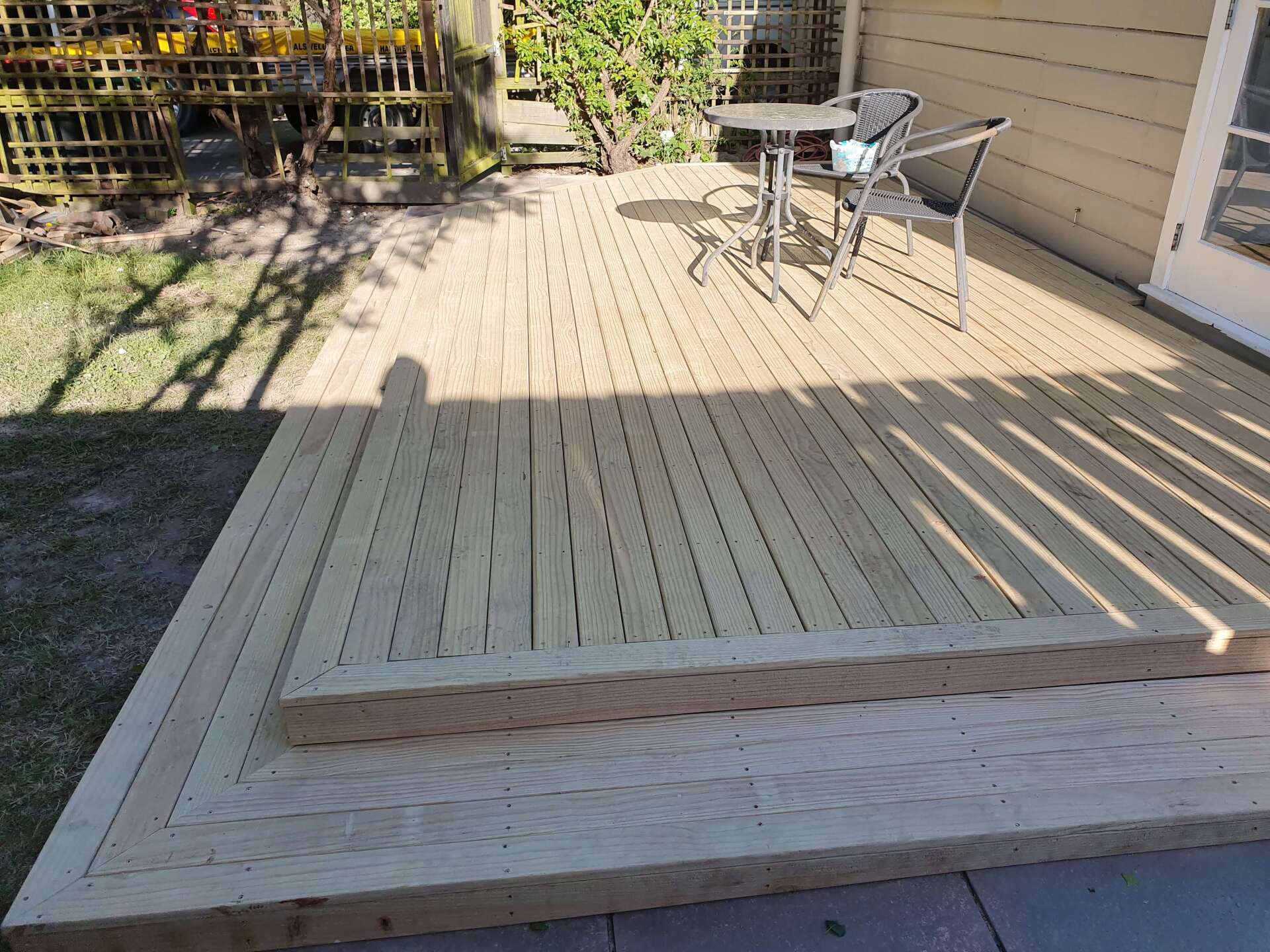 A wooden deck with a table and chairs on it.