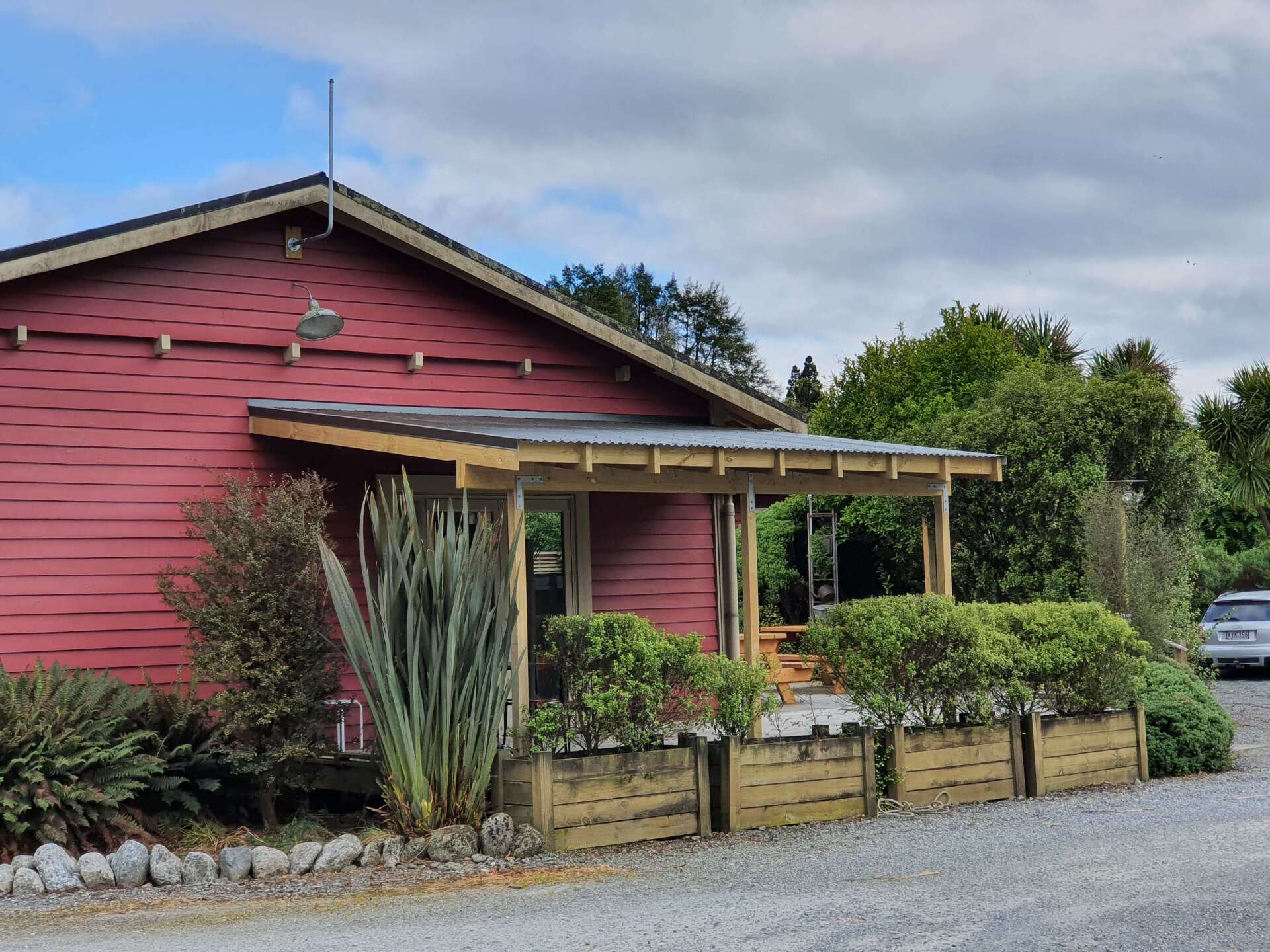 A red house with a car parked in front of it