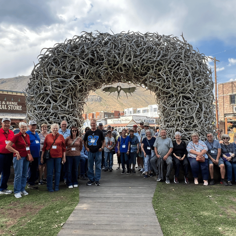 Group of people posing under an antler archway in Jackson Hole, Wyoming.