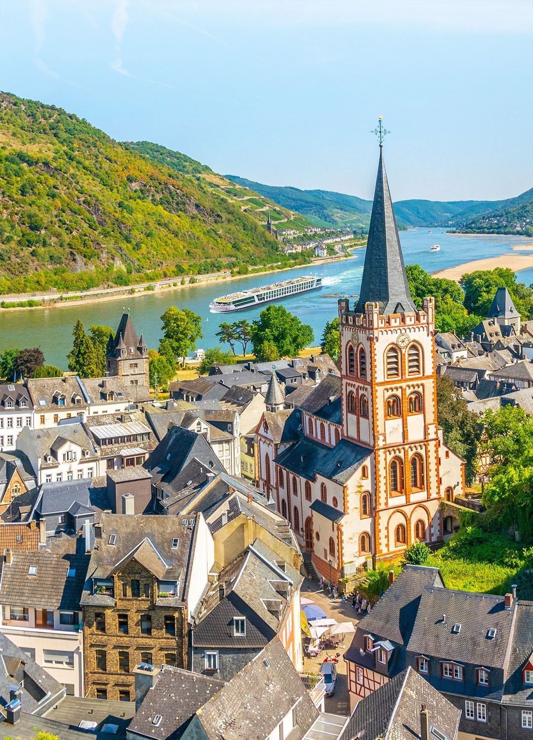 An aerial view of a small town with a church and a river in the background.