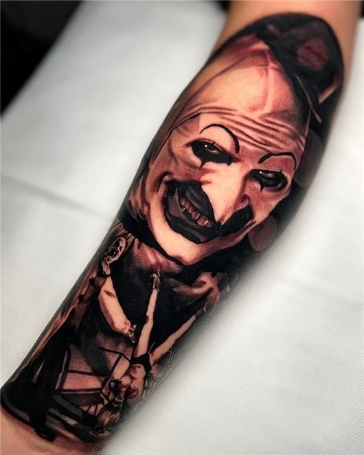 Arm with a black floral tattoo sleeve in cream and tan botanical patterns.